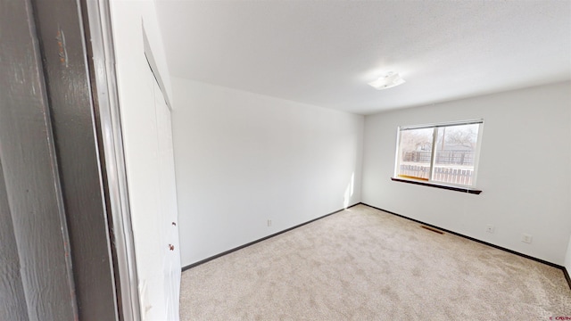 unfurnished room featuring light colored carpet