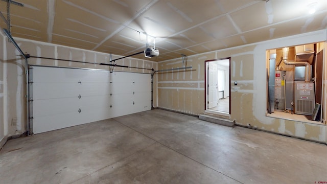 garage featuring a garage door opener, heating unit, and gas water heater