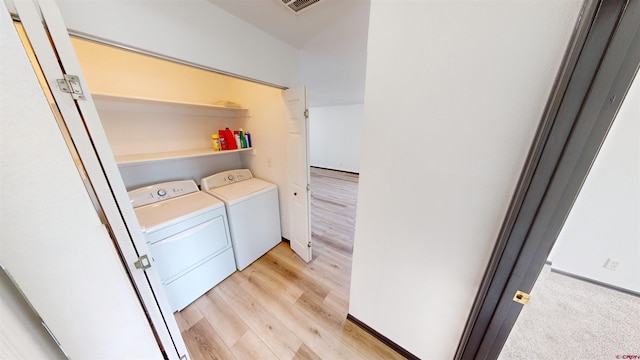 laundry area with independent washer and dryer and light wood-type flooring