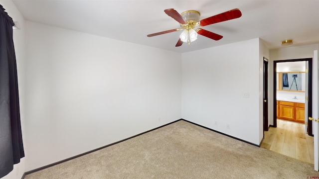 spare room with ceiling fan and light colored carpet