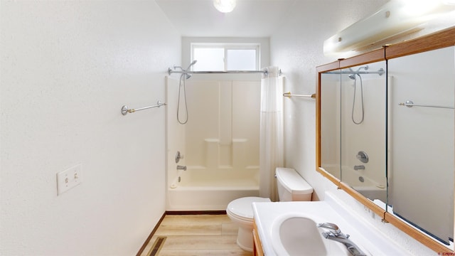 bathroom with hardwood / wood-style flooring, tub / shower combination, and toilet