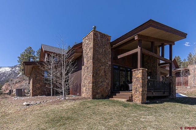 view of home's exterior with central AC unit and a lawn