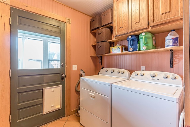 laundry room with light tile patterned floors, cabinets, and washing machine and clothes dryer