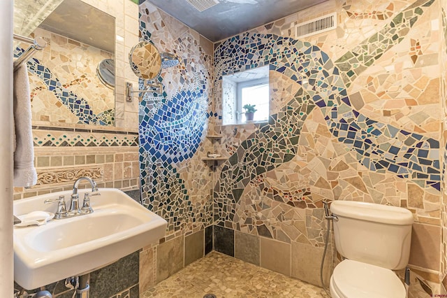 bathroom with sink, tile walls, and toilet