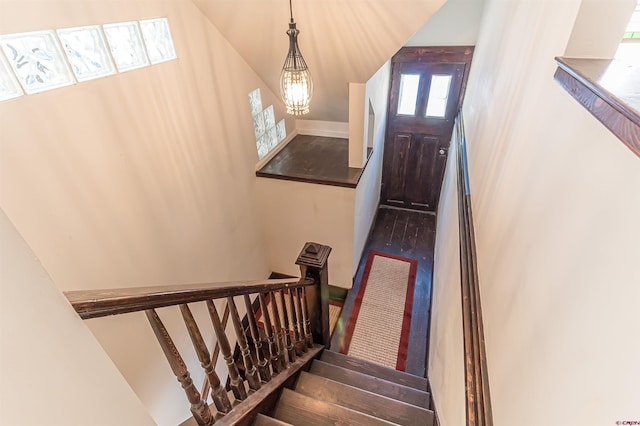 stairway with hardwood / wood-style flooring and a chandelier