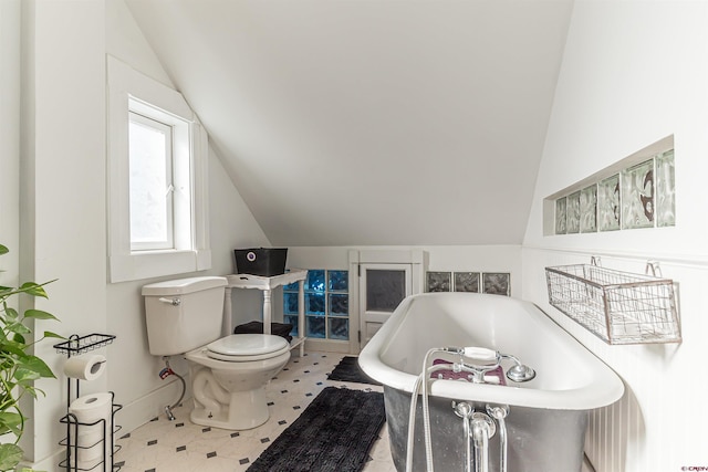 bathroom featuring vaulted ceiling, toilet, and a bathtub