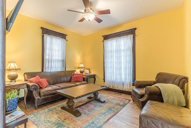 living room with ceiling fan and light hardwood / wood-style flooring