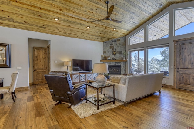 living room with high vaulted ceiling, a fireplace, ceiling fan, wood ceiling, and light wood-type flooring