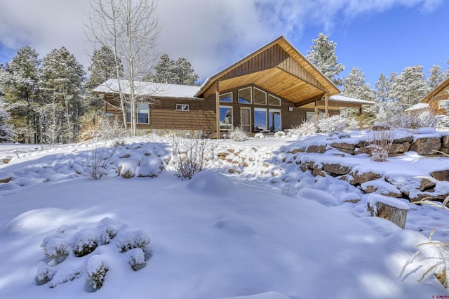 view of snow covered back of property