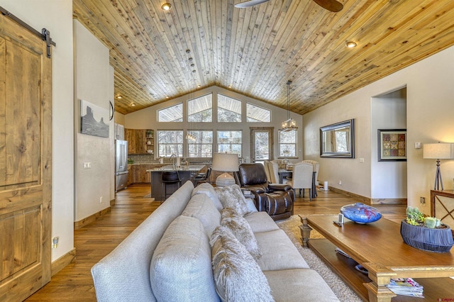 living room with ceiling fan with notable chandelier, high vaulted ceiling, wood-type flooring, wood ceiling, and a barn door