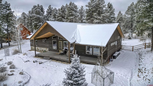 snow covered house featuring a deck