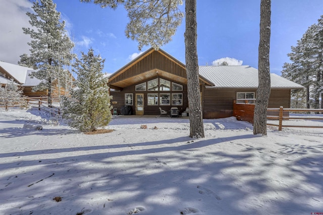 view of snow covered back of property