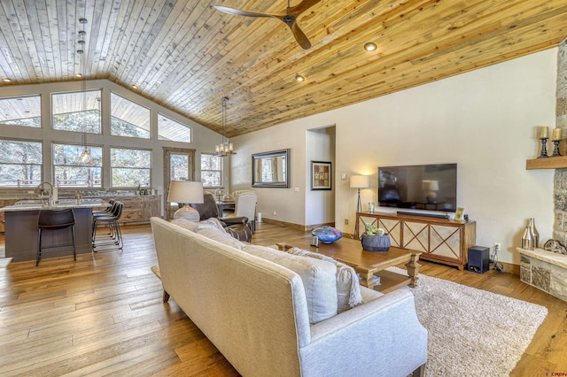 living room with high vaulted ceiling, ceiling fan with notable chandelier, wooden ceiling, and light wood-type flooring