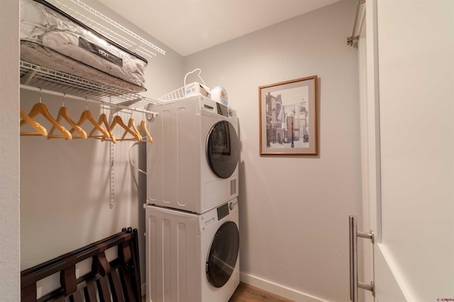 laundry area with stacked washer and dryer, laundry area, and baseboards