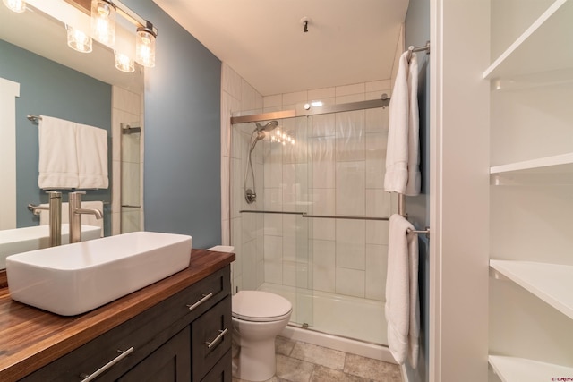 bathroom featuring toilet, a stall shower, stone finish flooring, and vanity