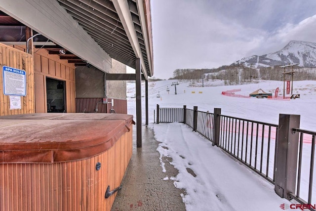 exterior space with a mountain view and a hot tub