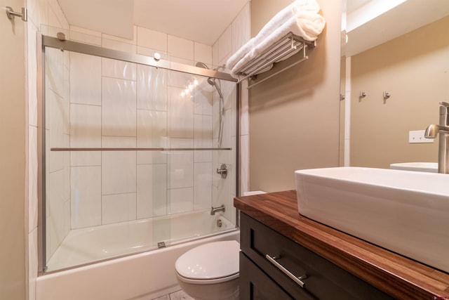 bathroom with toilet, shower / bath combination with glass door, and vanity