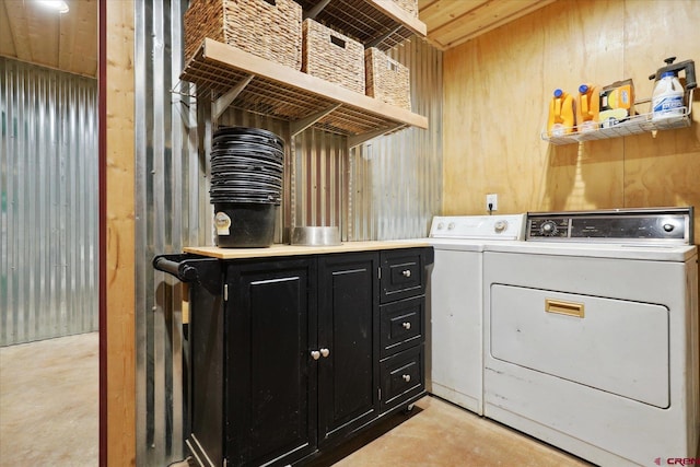 washroom with wooden walls and washer and clothes dryer