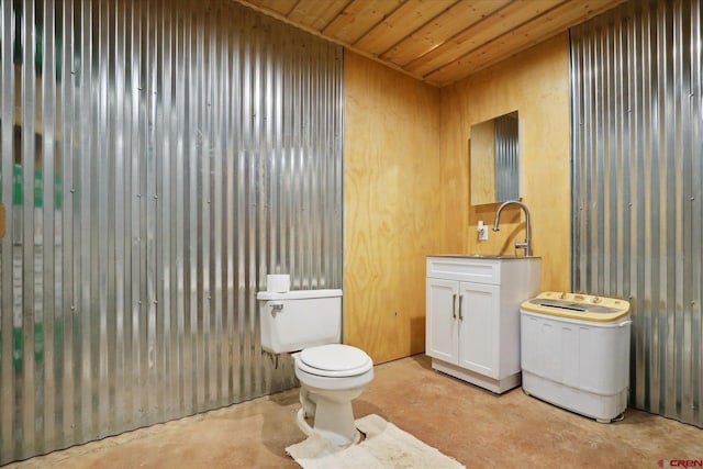 bathroom featuring wood ceiling, wooden walls, vanity, concrete floors, and toilet