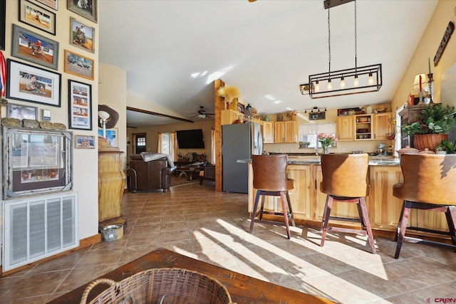 kitchen featuring lofted ceiling, a breakfast bar area, stainless steel fridge, and kitchen peninsula