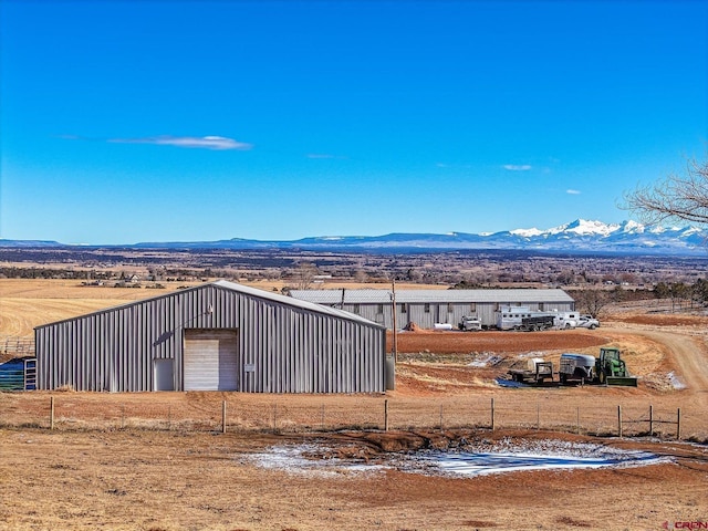 exterior space featuring a garage, a mountain view, and a rural view