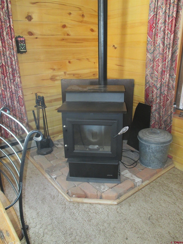 room details featuring wooden walls and a wood stove