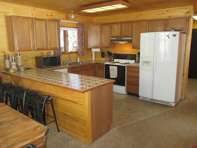 kitchen with a breakfast bar, sink, wood ceiling, kitchen peninsula, and white appliances