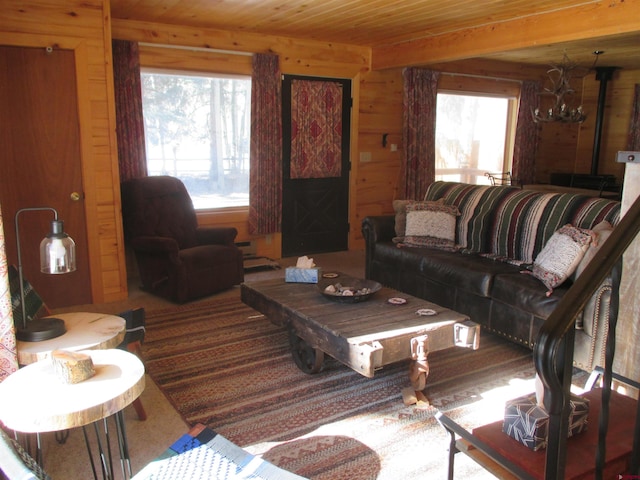 living room featuring wooden walls, a notable chandelier, and wood ceiling