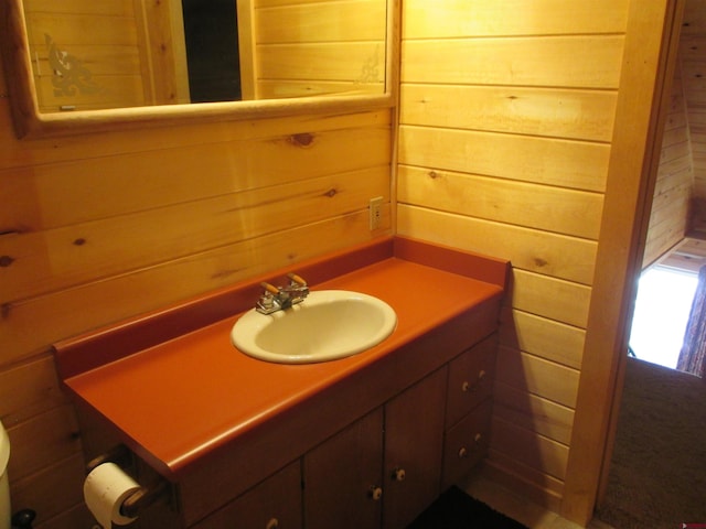 bathroom with vanity and wood walls