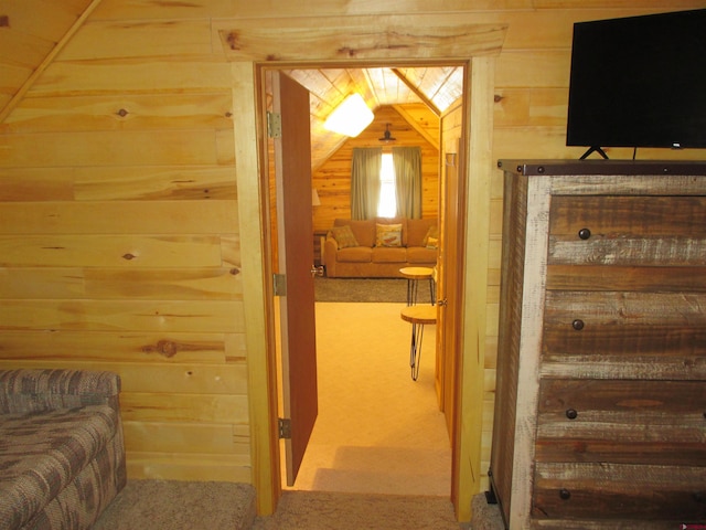 hall with carpet flooring and wooden walls