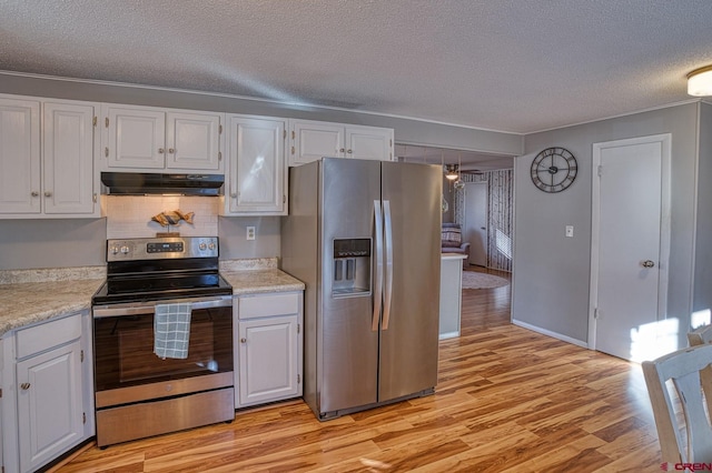 kitchen with appliances with stainless steel finishes, white cabinetry, light hardwood / wood-style floors, a textured ceiling, and decorative backsplash