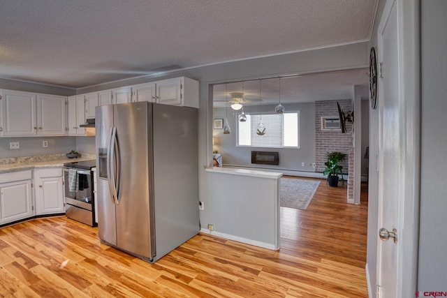 kitchen with appliances with stainless steel finishes, pendant lighting, white cabinetry, a textured ceiling, and light hardwood / wood-style flooring