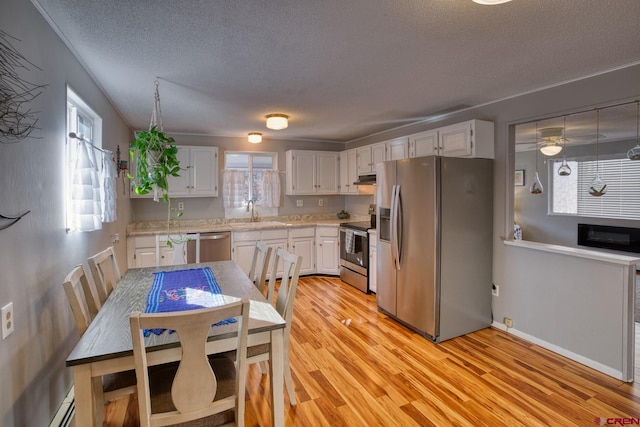 kitchen with white cabinetry, plenty of natural light, appliances with stainless steel finishes, and light wood-type flooring