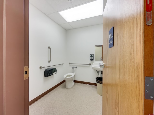 bathroom featuring a drop ceiling and toilet