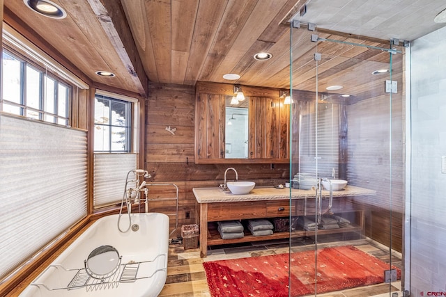 bathroom featuring wood walls, hardwood / wood-style flooring, vanity, a washtub, and wood ceiling