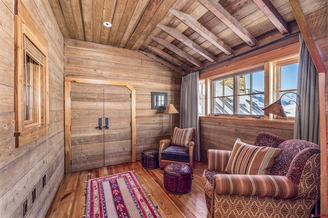 sitting room featuring hardwood / wood-style flooring, vaulted ceiling with beams, wooden ceiling, and wood walls