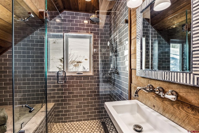 bathroom with tile walls, sink, and walk in shower