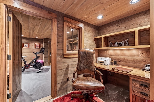 living area featuring wood ceiling, built in desk, and wood walls