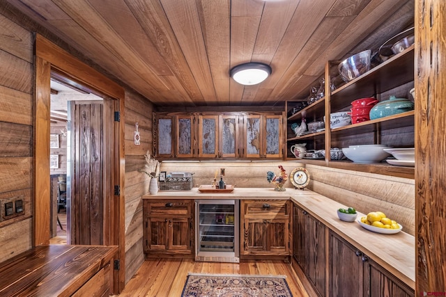 bar featuring wine cooler, wooden walls, wooden ceiling, and light hardwood / wood-style floors