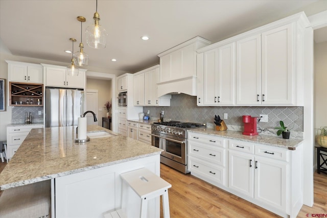 kitchen featuring an island with sink, appliances with stainless steel finishes, and sink