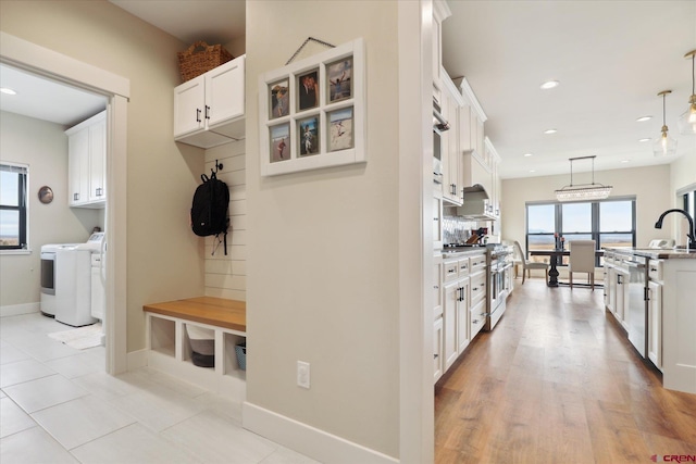 mudroom featuring washing machine and clothes dryer and light tile patterned floors