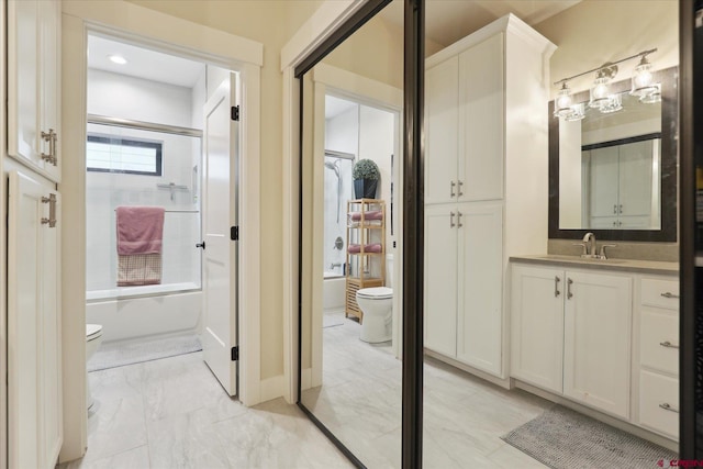 full bathroom with vanity, combined bath / shower with glass door, and toilet