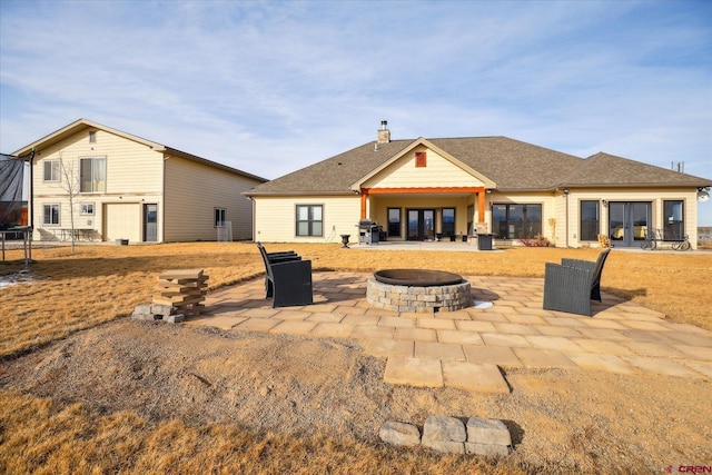 rear view of property with a fire pit and a patio area