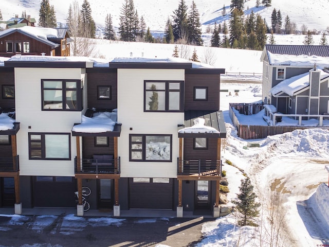 snow covered building featuring a garage