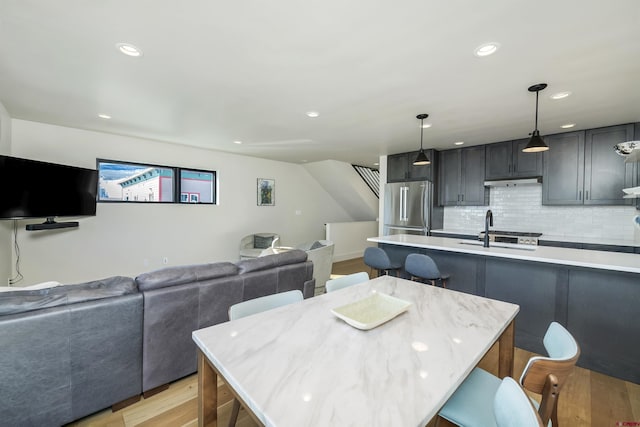 dining space featuring sink and light wood-type flooring