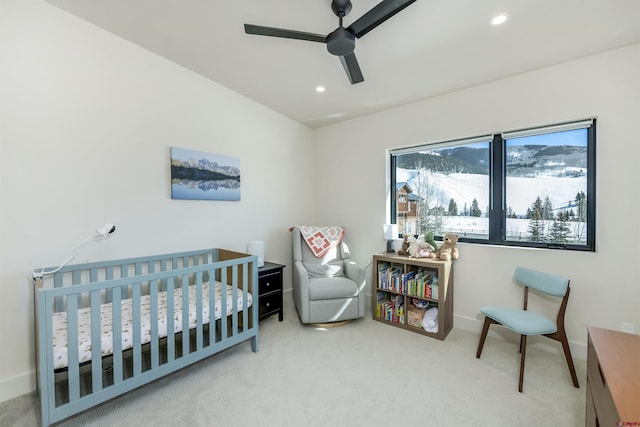 bedroom with carpet floors, a nursery area, and ceiling fan