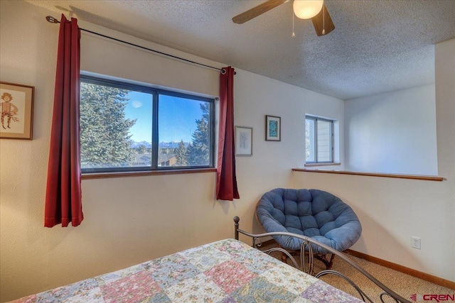 bedroom featuring ceiling fan, carpet floors, and a textured ceiling