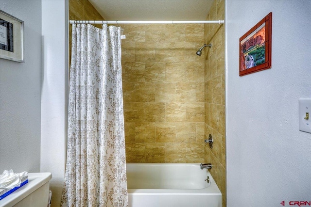 bathroom featuring shower / bath combo and toilet