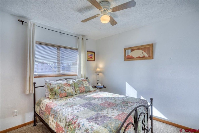 carpeted bedroom with ceiling fan and a textured ceiling