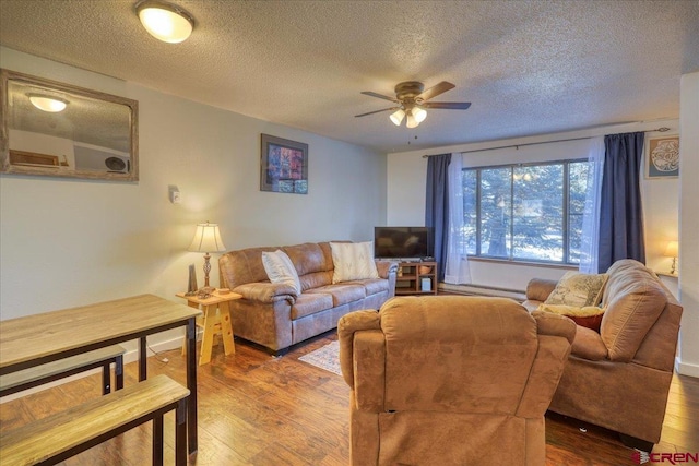 living room with hardwood / wood-style flooring, a textured ceiling, and ceiling fan